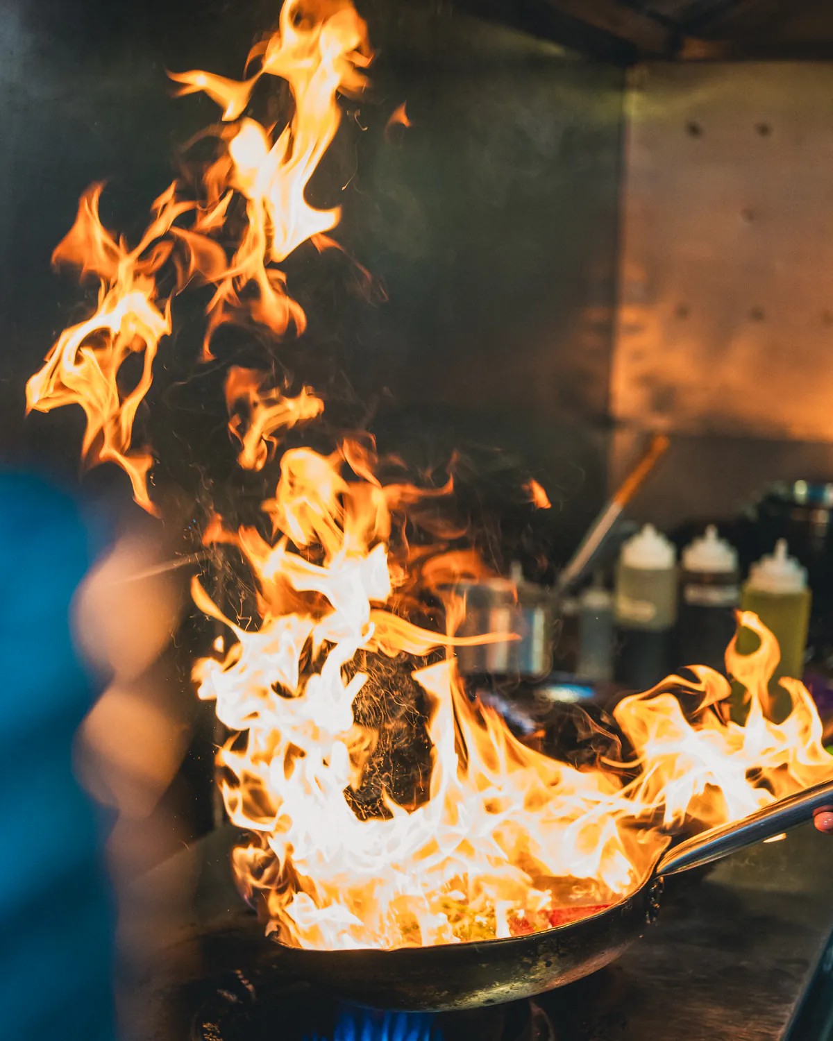 Salteado al wok entre llamas, en la cocina